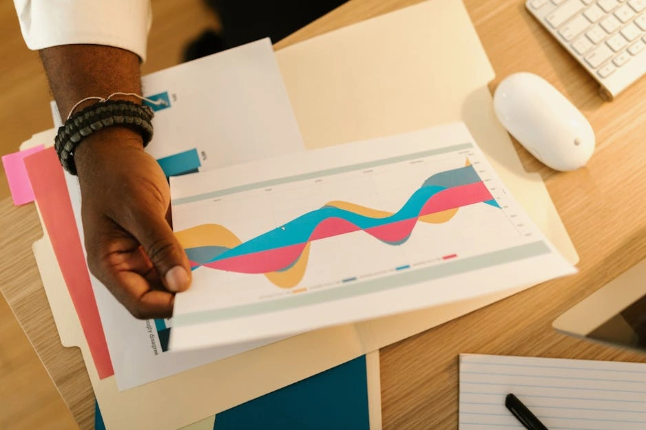 Una persona che pianifica le proprie finanze su un taccuino in un ambiente di lavoro sereno.